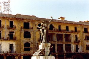 Photo of a burned out building behind the central sculpture in Martyr's Square, Beirut, 1982
